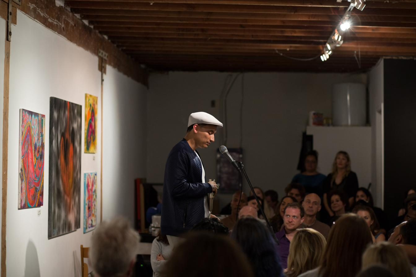 Paint The Mic — a performer at the microphone among the artwork